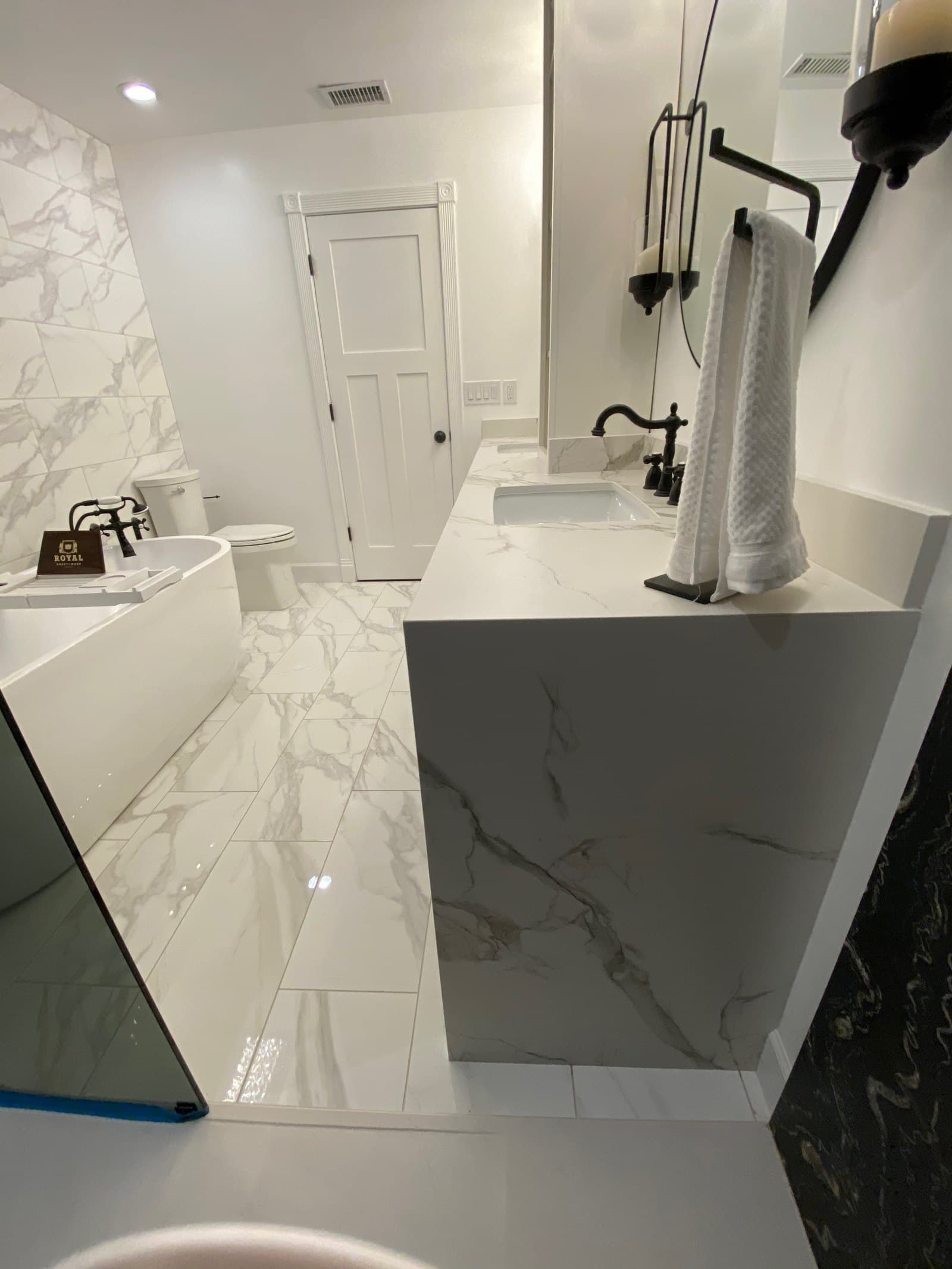 Marble vanity, custom cabinetry, and full-height stone tilework