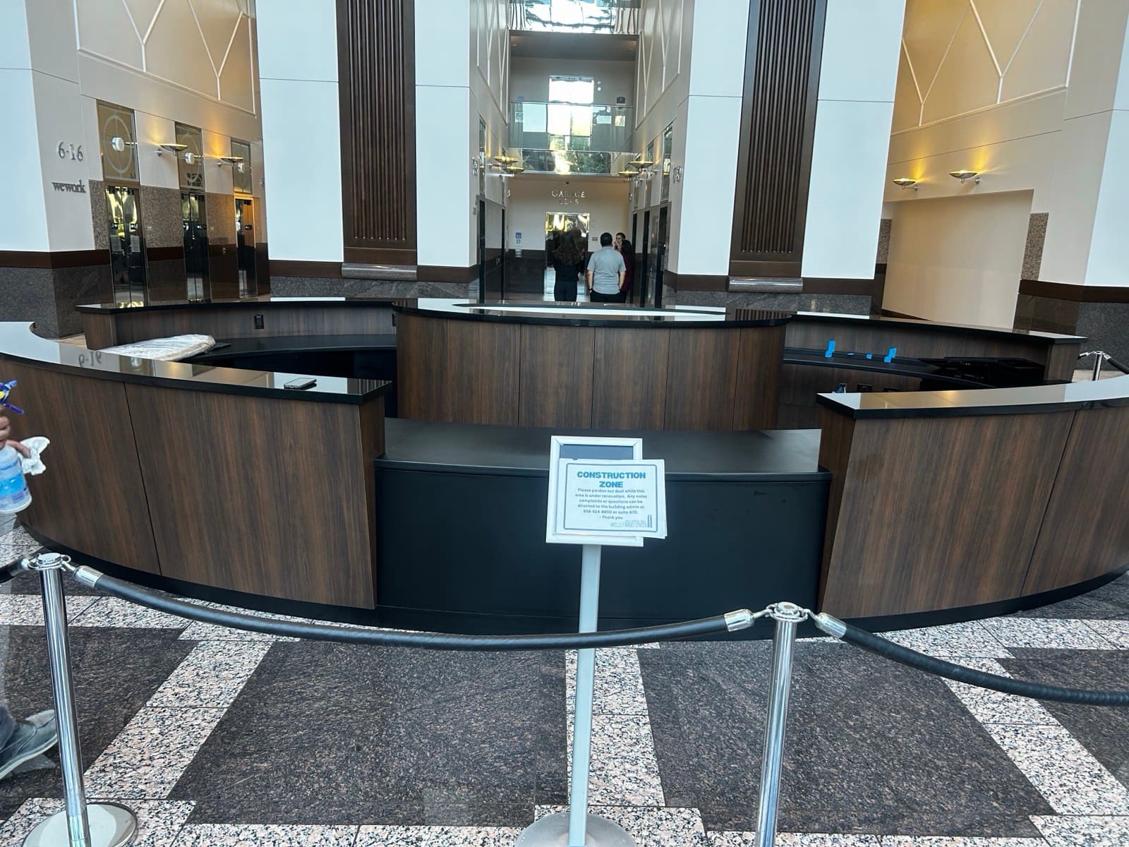 Close-up of curved black stone desk ledges over walnut paneling